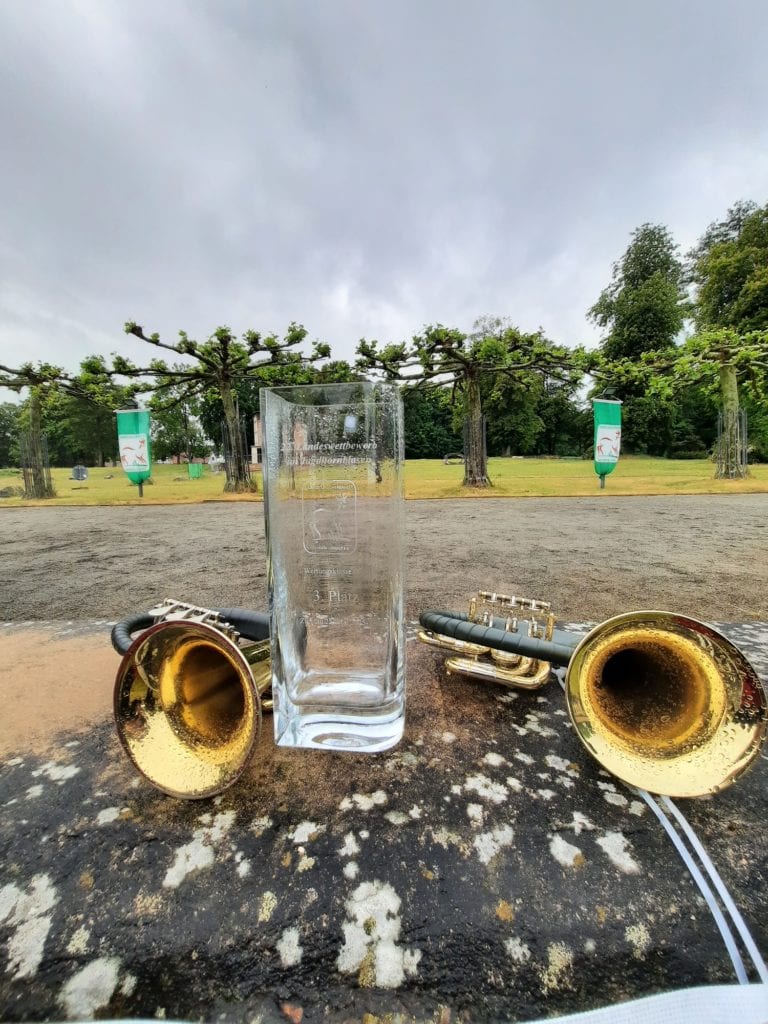 Glas und Trompeten im Park bei Regen.
