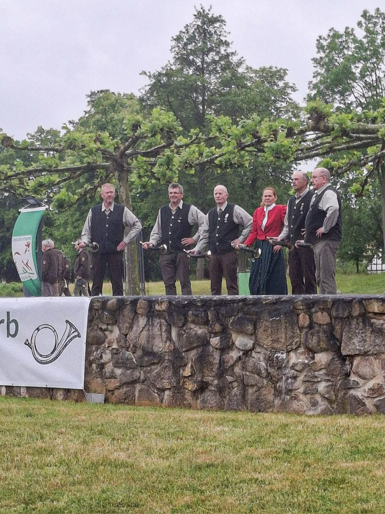 Gruppe von Leuten in traditioneller Kleidung im Freien.